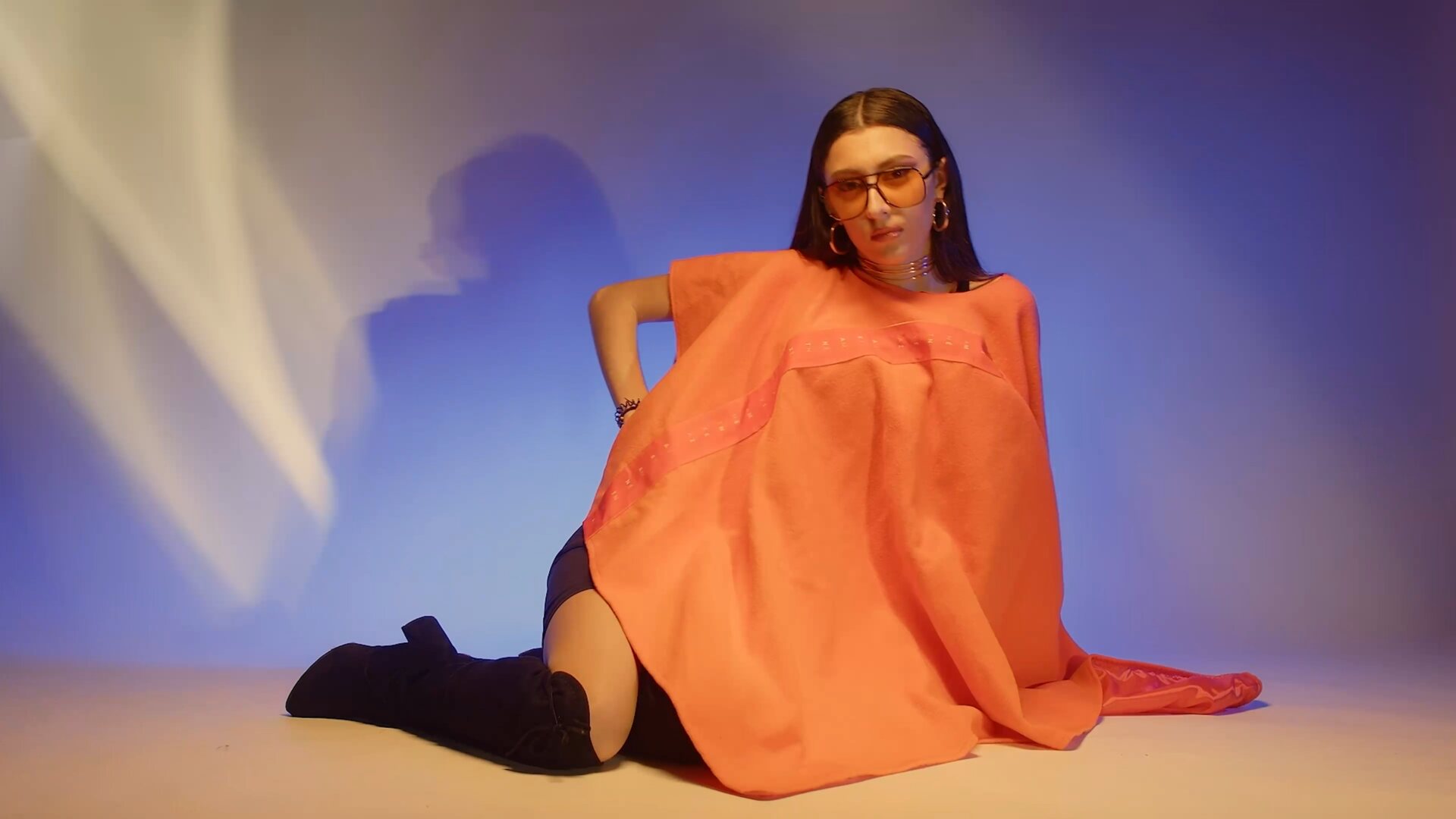 Orange cape on blue background — saturated colour contrast